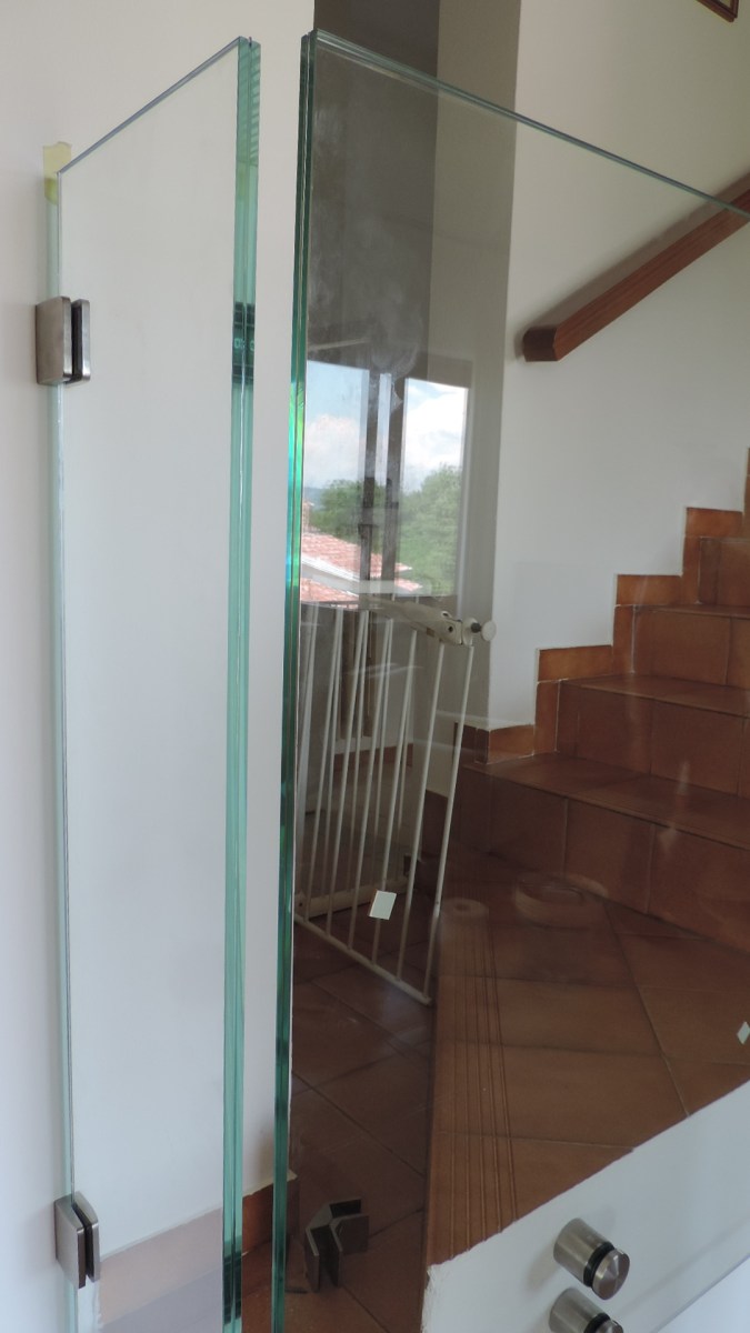 particolare della lastra in vetro di angolo con la balaustra in vetro del balconcino