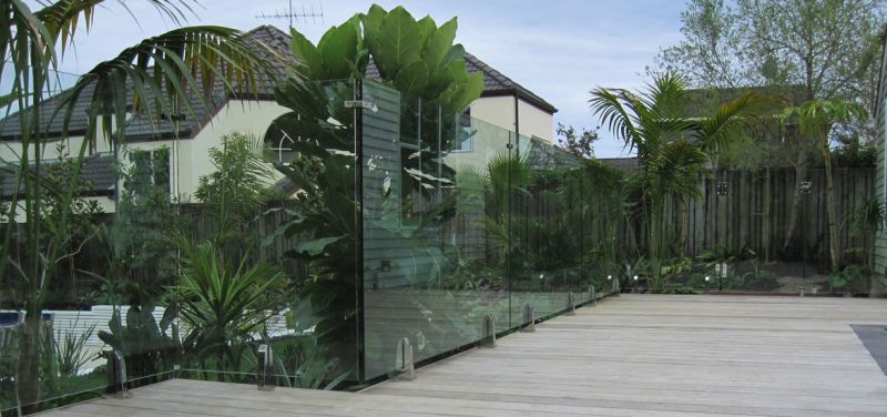 vetro come barriera tra giardino piantumanto e piscina