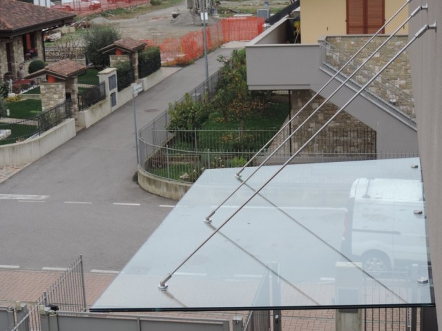 copertura in vetro con tiranti paralleli in acciaio e mensole di sostegno