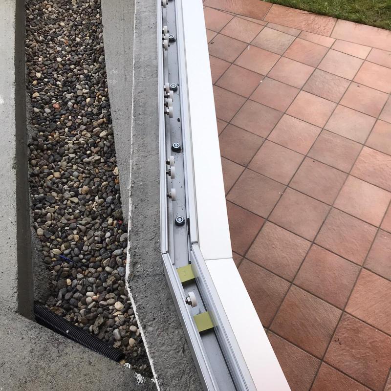 particlare dell'angolo con i fissaggi in vista della divisoria/recinzione in vetro